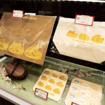 オリジナルグッズも店頭にて購入可能。ランチョンマット（1320円・税込）やランチサイズトートバッグ（1,980円・税込）など食にまつわるアイテムのほか、ちいかわ焼きモチーフのちいかわ・ハチワレ・うさぎが描かれたガーゼハンドタオル（各825円・税込）も。